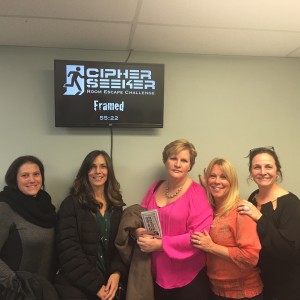 A group of women standing in front of a sign.